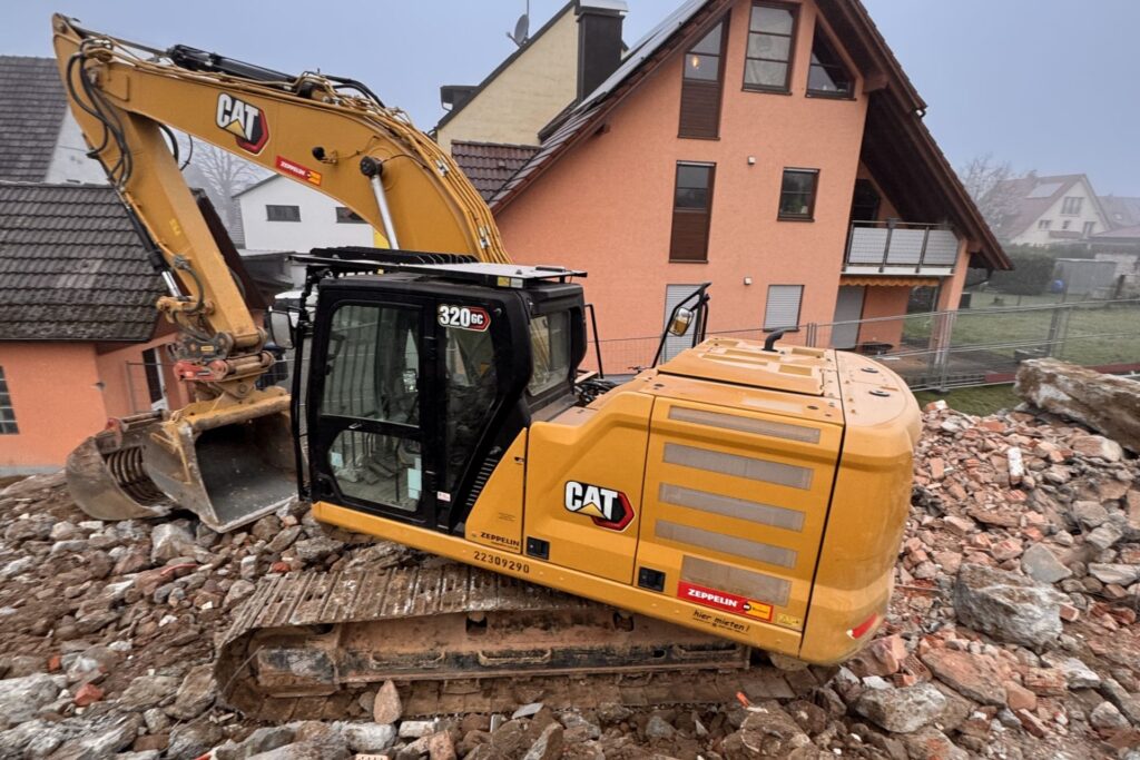 CAT-Bagger der KLB BAU GMBH beim Hausabbruch auf einer Baustelle